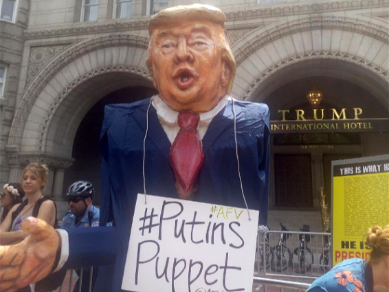 statue of Trump wearing a label with the text 'Putins puppet'