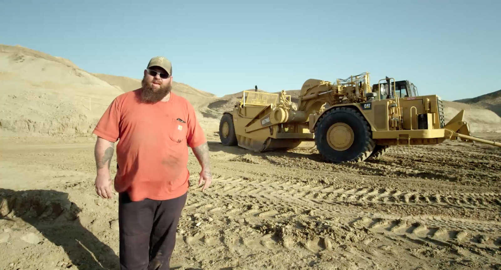 Steven Kuzar standing in front of the Caterpillar truck in the San Fernando Valley from documentary film Earth